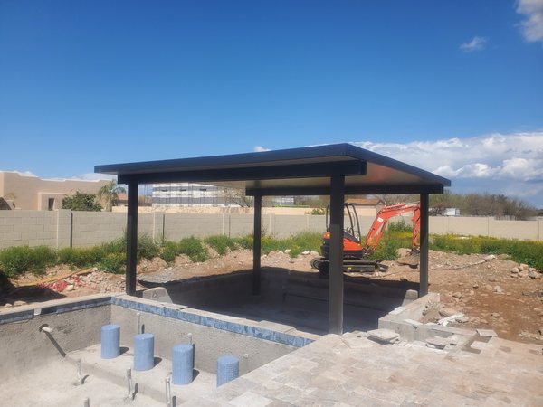 Black freestanding patio cover on a new backyard slab for Las Vegas area homeowners.